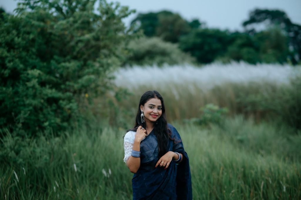 woman-in-blue-sari-posing-in-lush-green-field-31978135